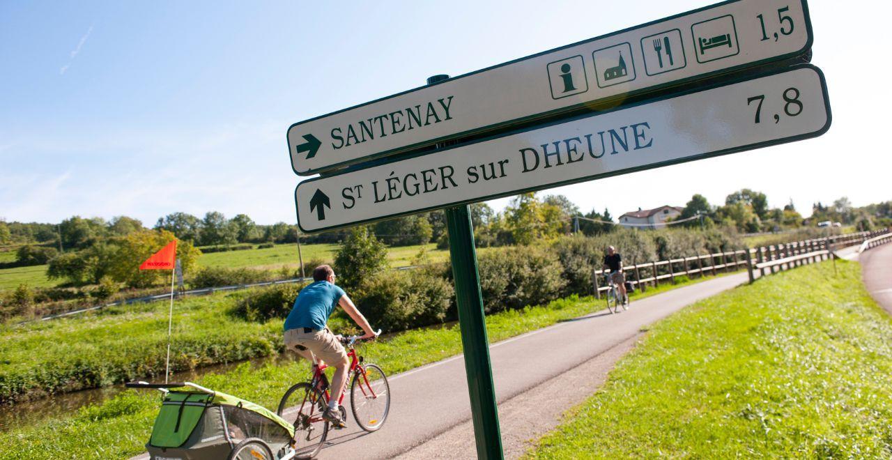 Cyclists on a path with signposts to Santenay and St. Léger sur Dheune.
