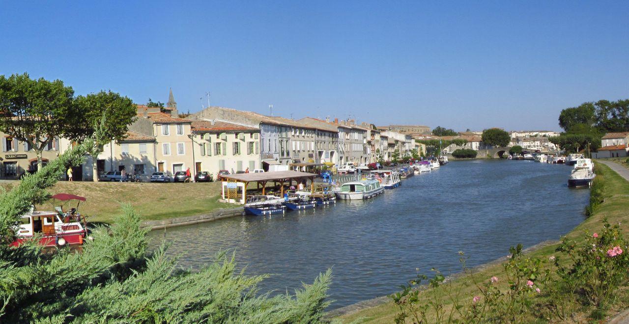 Boats docked along Canal du Midi with buildings in the background.