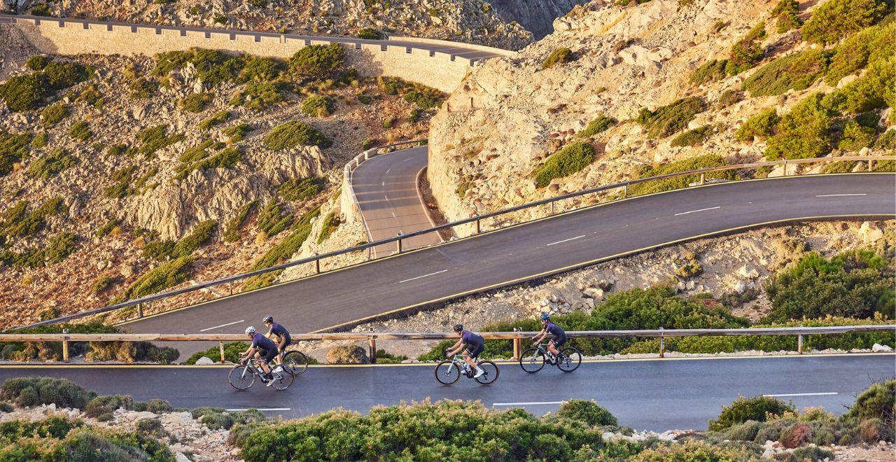 Cyclists riding up to Cap Fomentor lighthouse in Mallorca