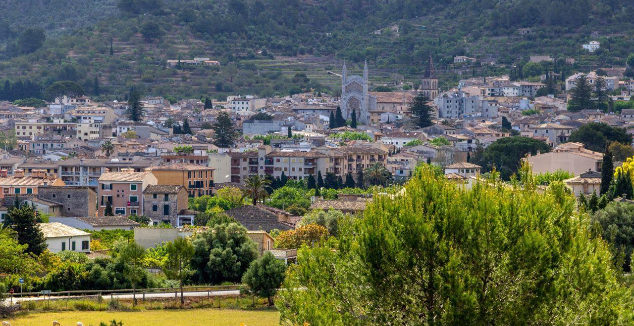 Town nestled in a valley with a large church and surrounding greenery.