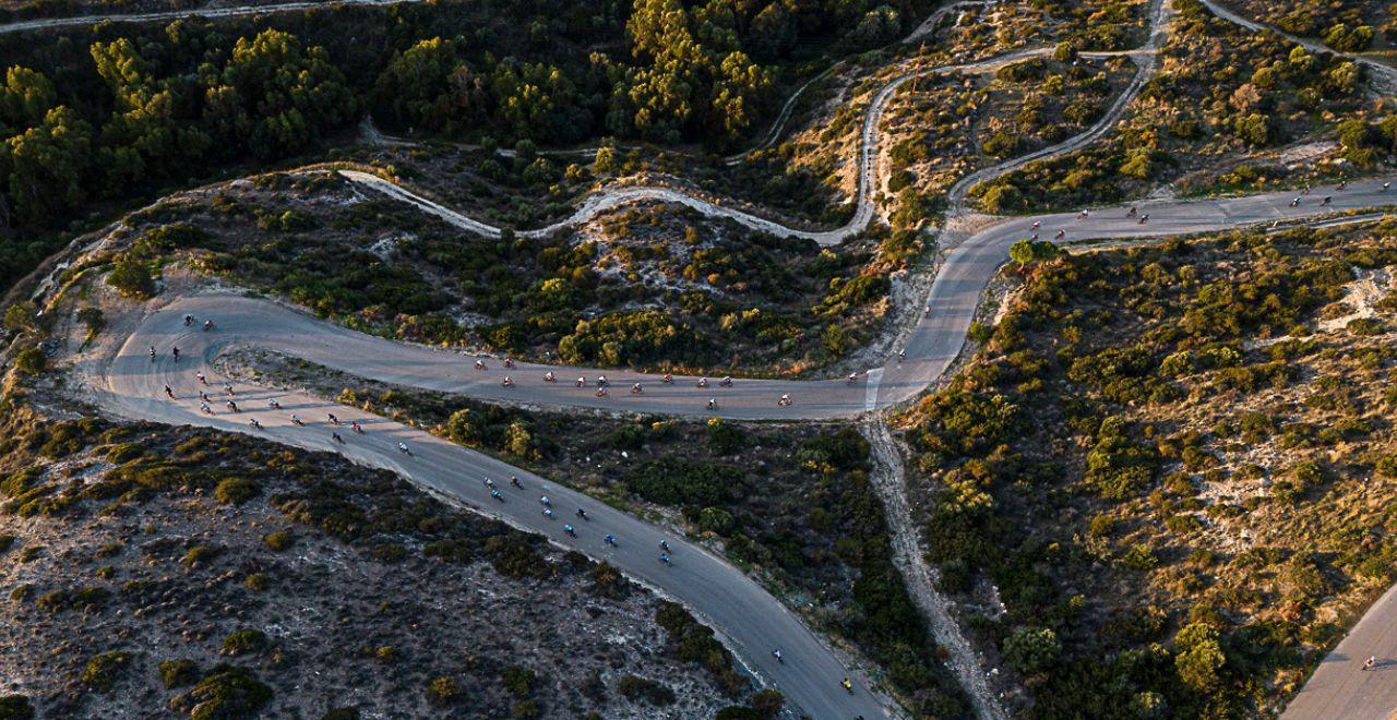 Cyclists navigating a challenging mountain road with sweeping views of Cyprus's landscape, perfect for those who love steep climbs and thrilling descents