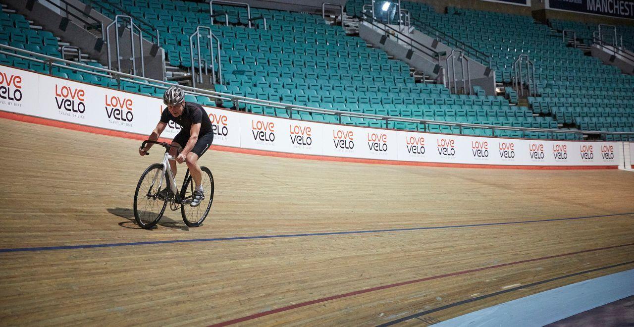 Cyclist riding on an indoor velodrome track.