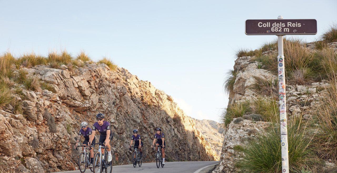 Cyclists ascending Coll dels Reis in Mallorca, experiencing challenging climbs and breathtaking views with Love Velo