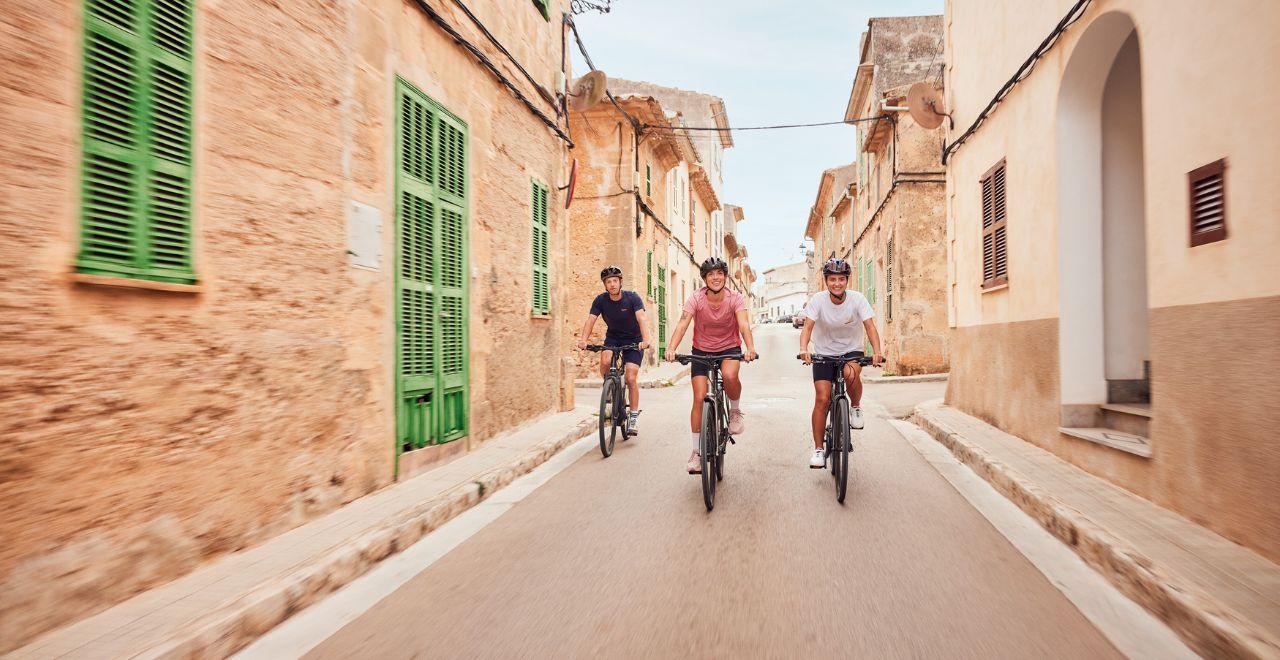 Group of cyclists riding through a quaint village.