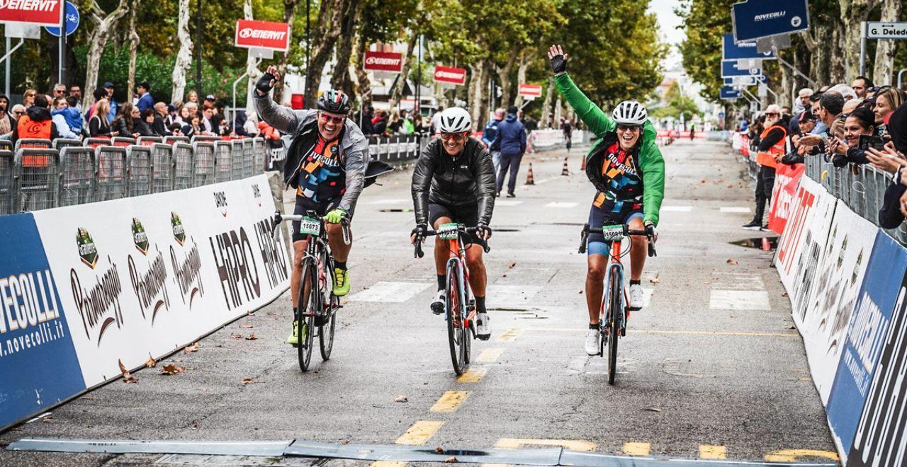 Three cyclists celebrating as they cross the finish line.