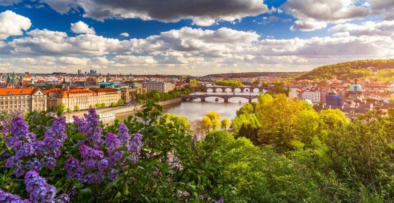 A scenic view of Prague with multiple bridges over the Vltava River and the cityscape in the background