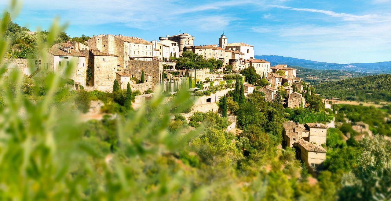 A hilltop village in Provence with greenery in the foreground