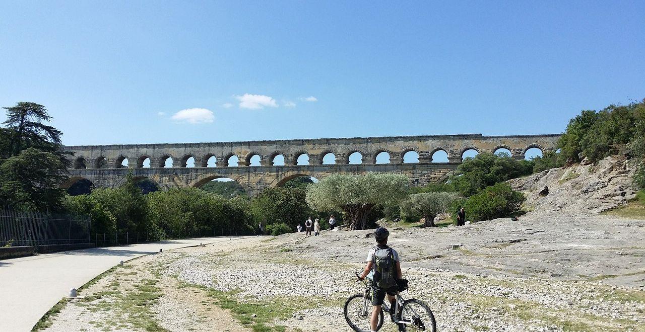 A cyclist at an old Roman aqueduct in Orange, Provence