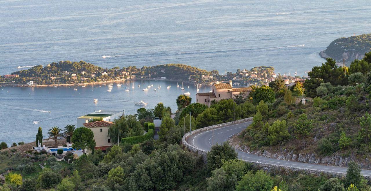 View of a winding road and St Jean Cap Ferrat peninsular in the distance