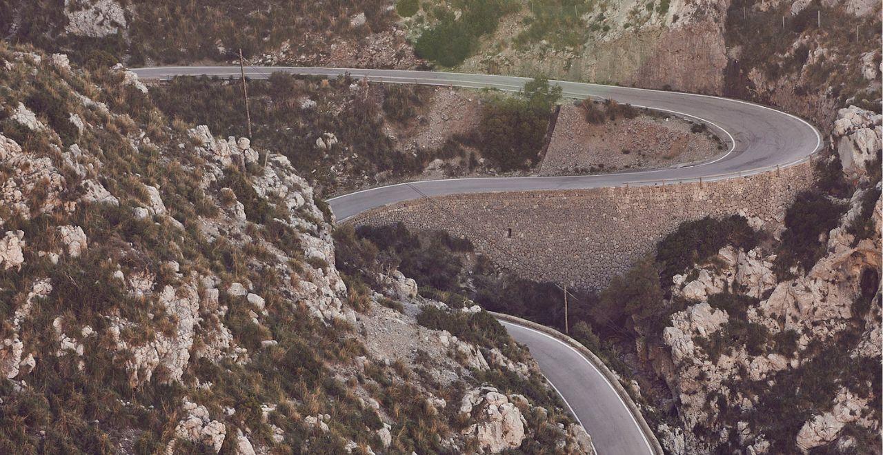 Hairpin turns on a mountain road surrounded by rocky terrain in Mallorca.