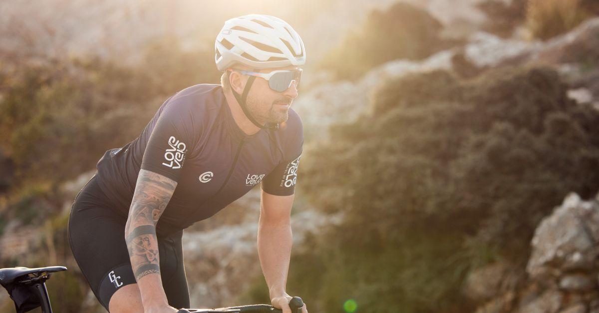 Determined cyclist in the golden glow of the sunset, riding through rugged terrain with focused intensity