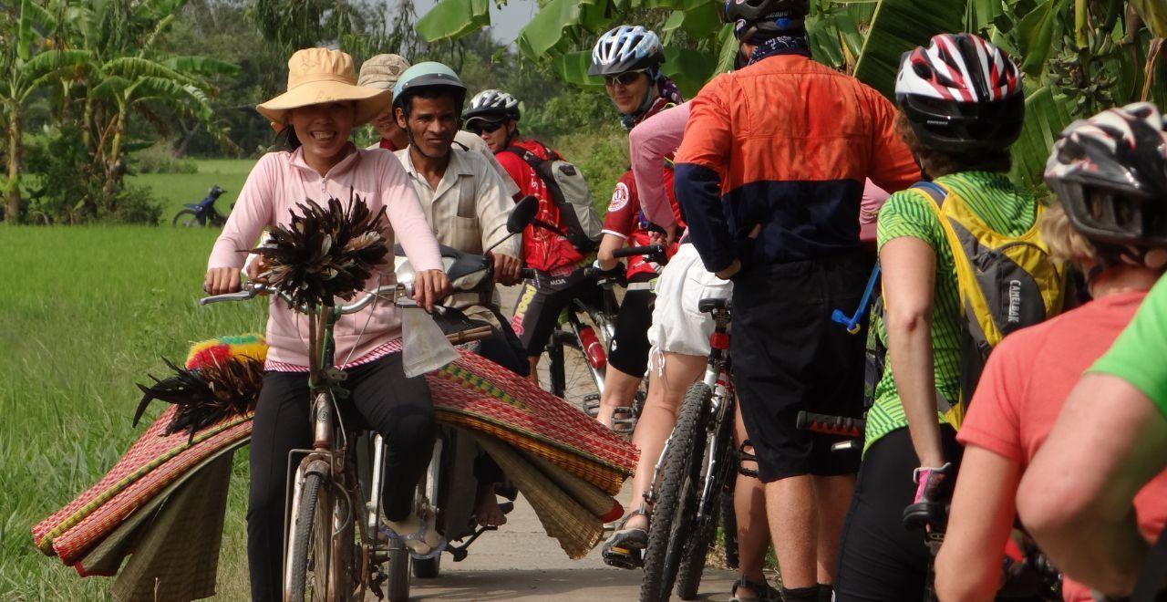 Group of cyclists meeting locals on a rural path