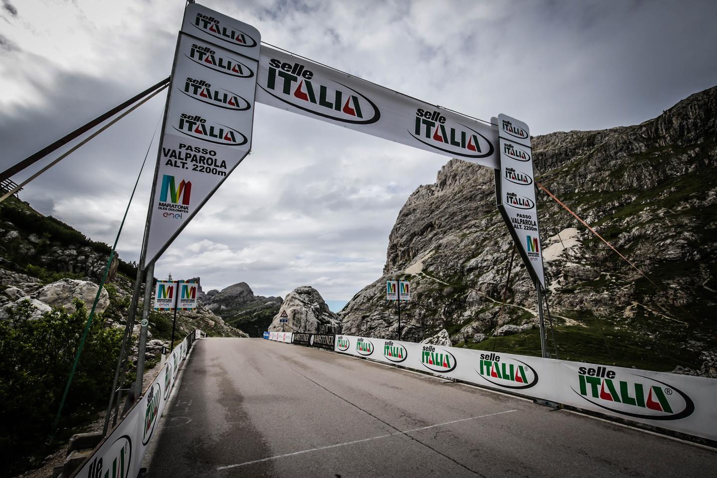 Passo Valparola in the Dolomites, Italy, marked by a cycling race banner and surrounded by stunning mountain scenery.