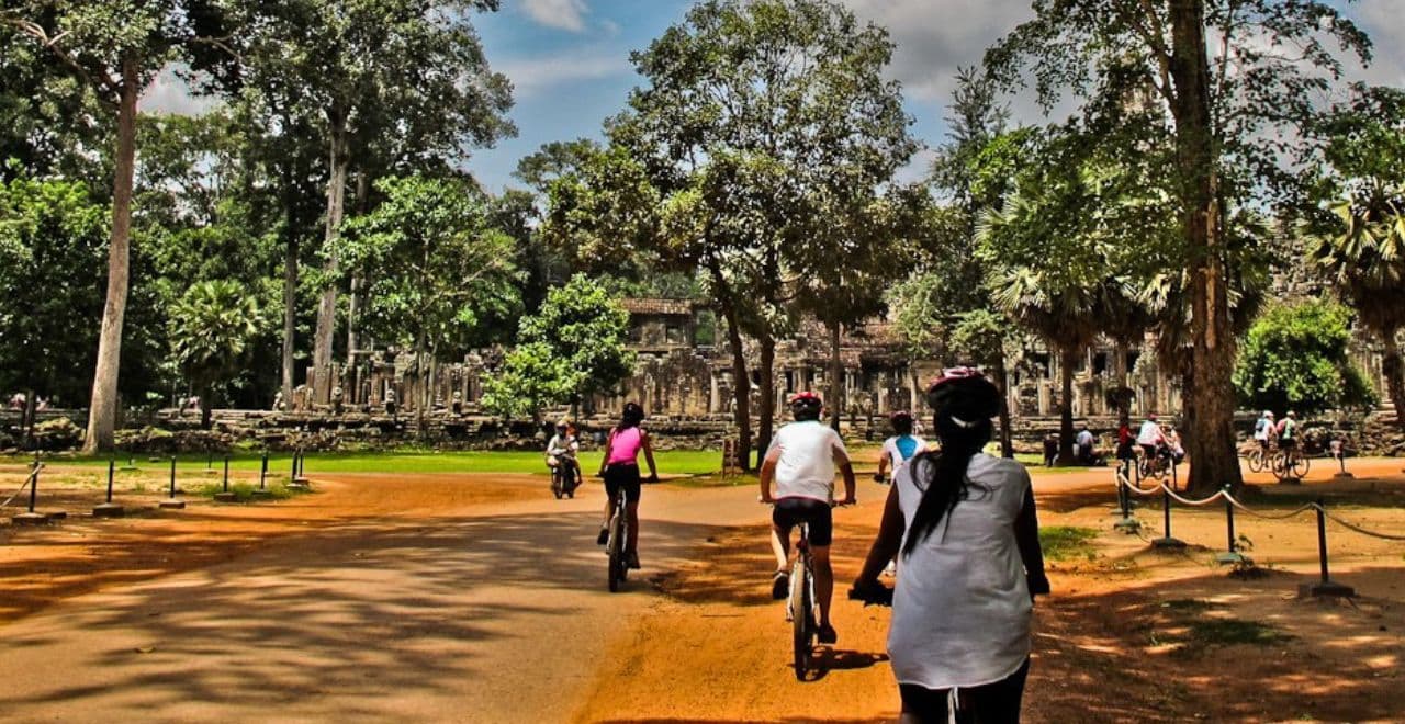 Cyclists riding through an archaeological site with ancient ruins