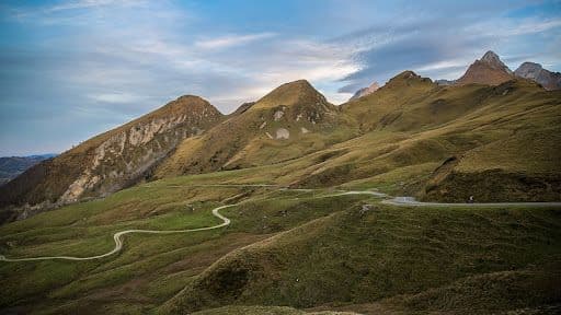 Rolling hills and winding roads of Col du Soulor during dusk.