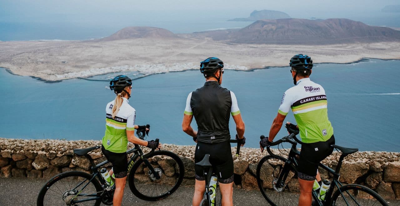 Cyclists stopping to admire the ocean view from a coastal road.