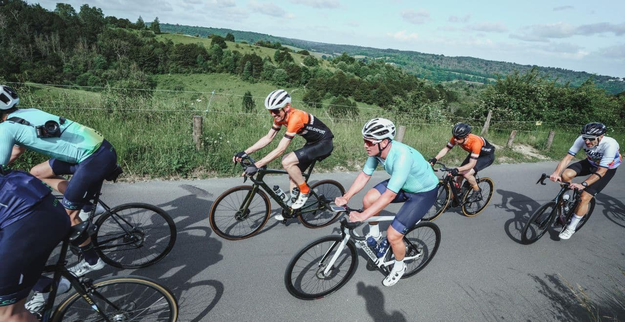 Group of cyclists climbing a scenic rural road during a ride