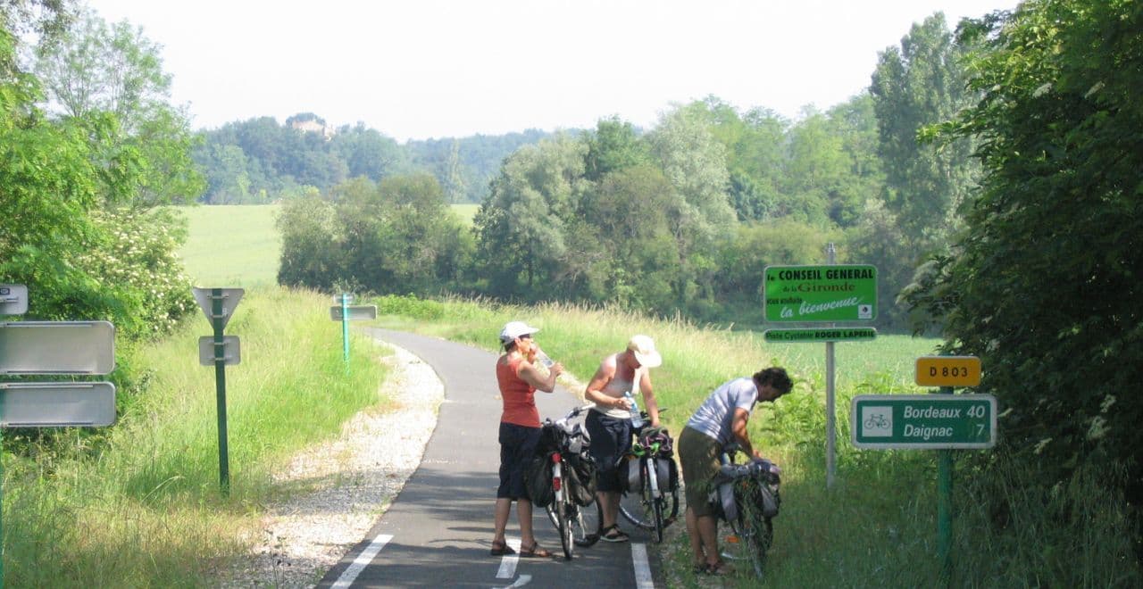 3 cyclists taking a break on a road through fields in Bordeaux