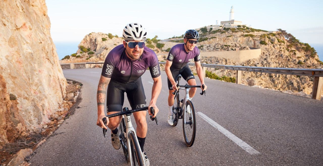 Cyclists riding on a mountain road near lighthouse