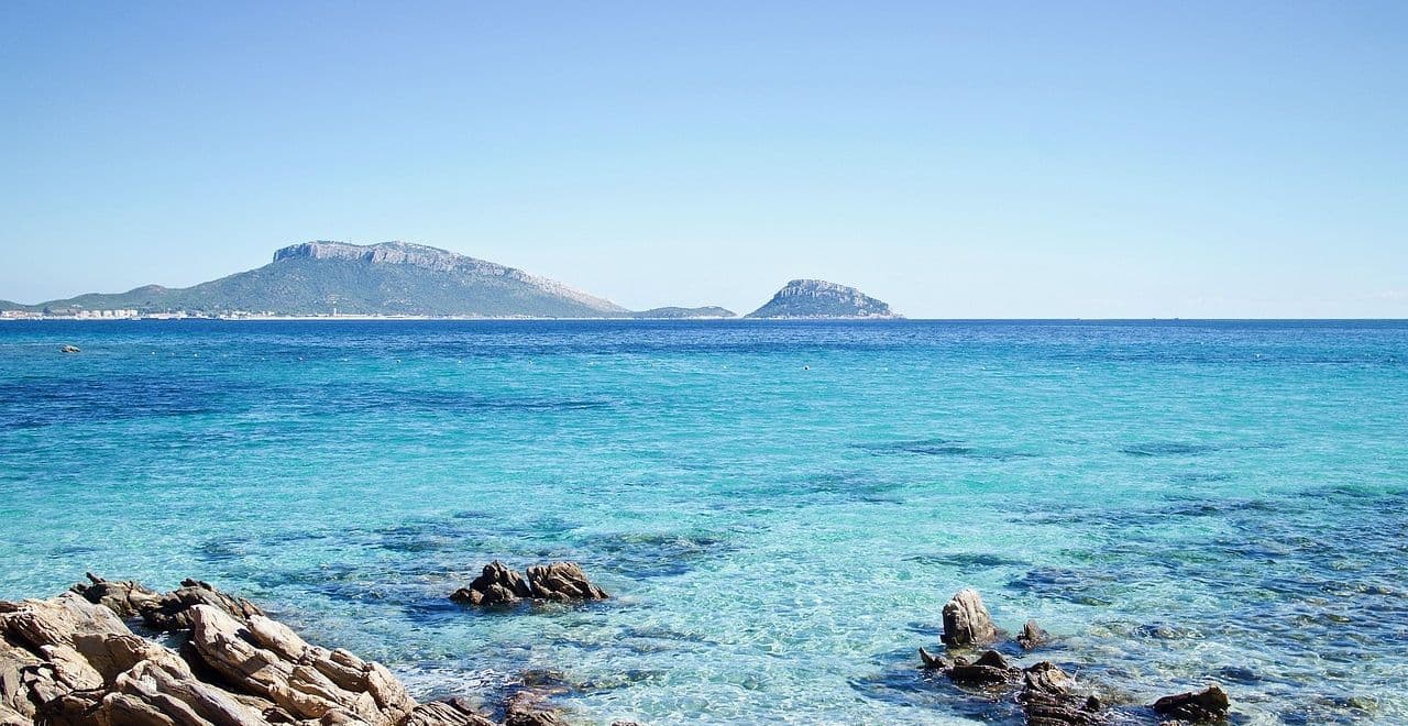 Crystal-clear turquoise sea with distant Sardinian islands