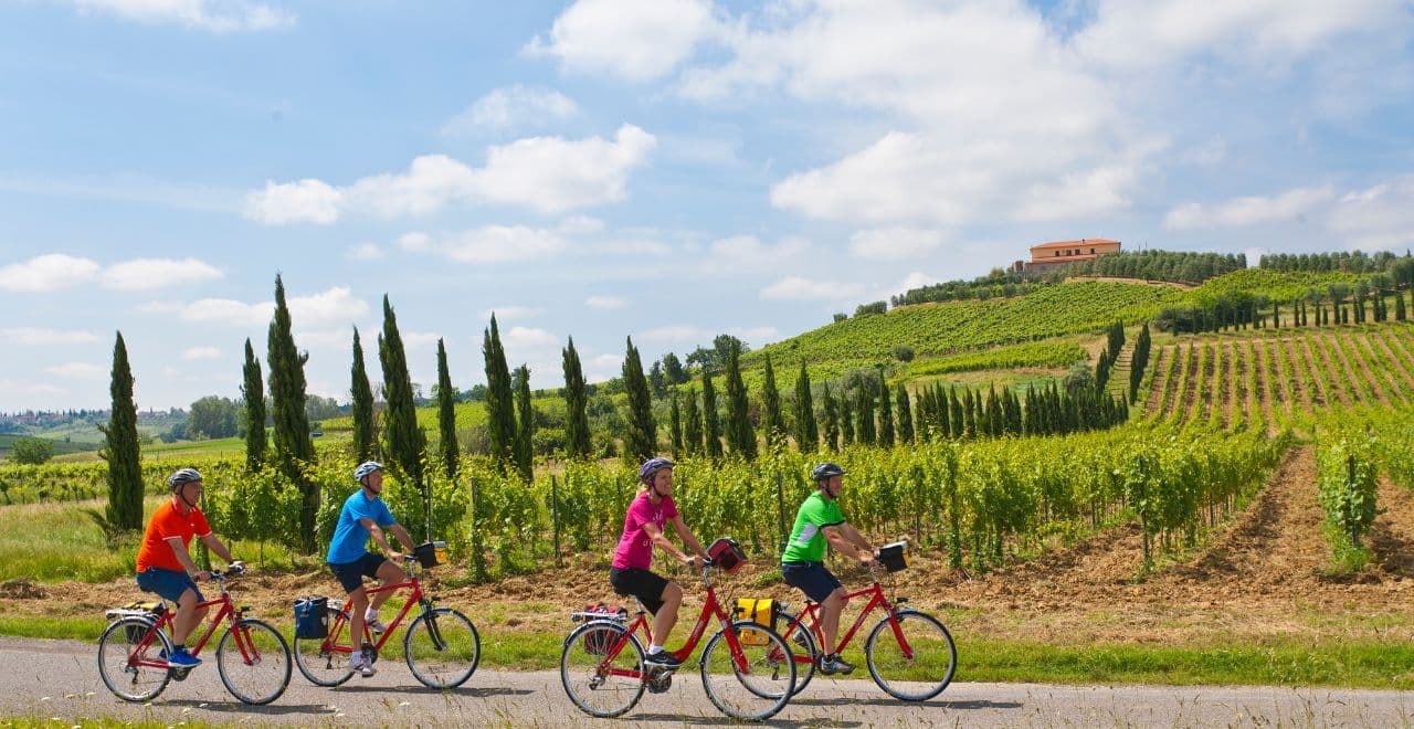 Group cycling through scenic vineyards in Tuscany