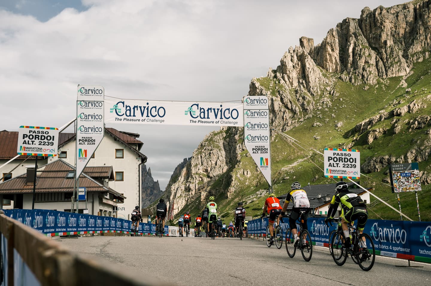 Finish line of Passo Valparola climb in the Dolomites, Italy, with Selle Italia banners and mountain scenery.