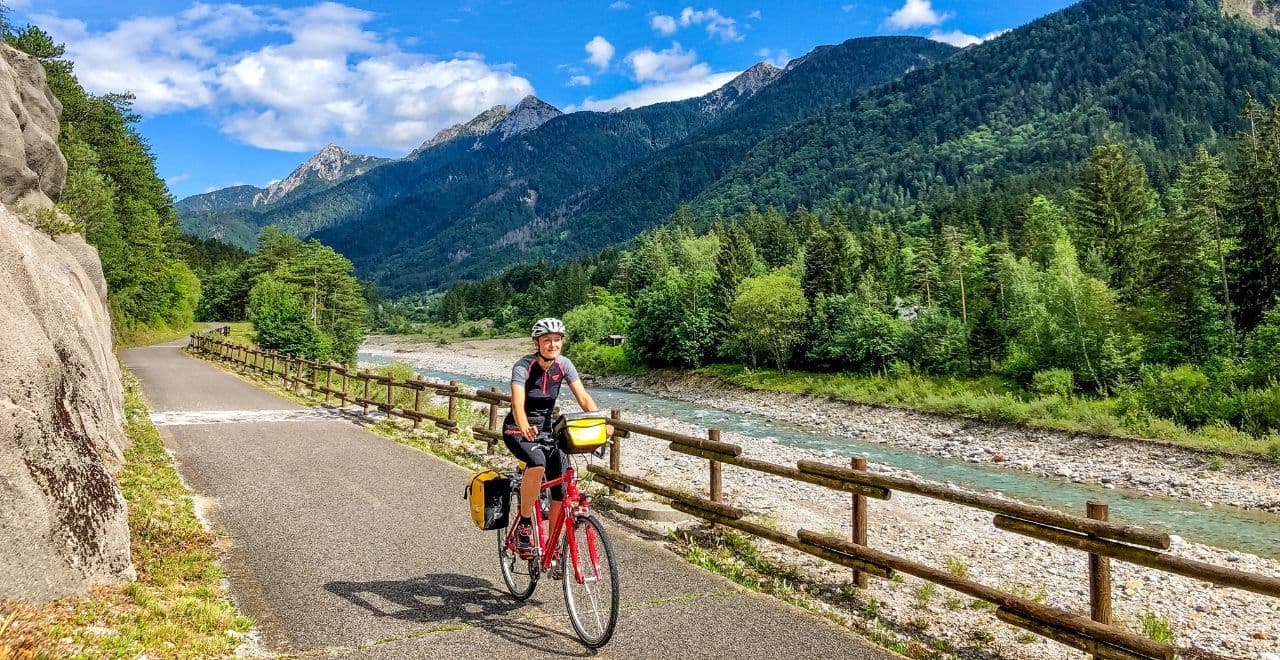 Cyclist riding along a riverside mountain trail Ask ChatGPT