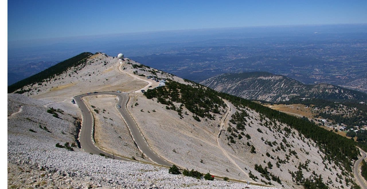Aerial view of the winding road on Mont Ventoux with a radar dome in the background.