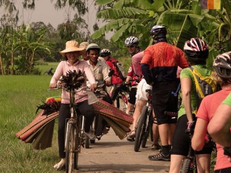 Cyclists ride along the plantations in Thailand 