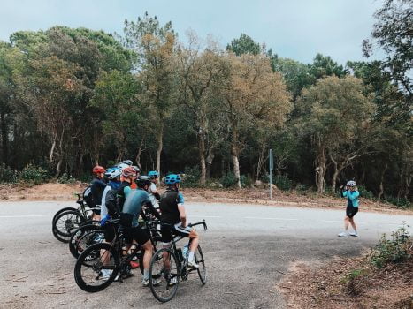 Woman takes picture of group of cyclists 