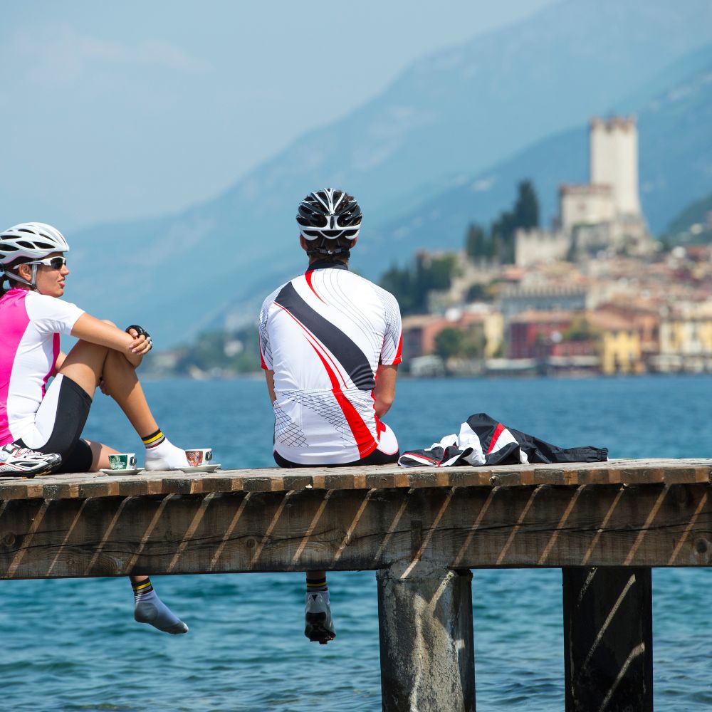 2 cyclists on a pier overlooking lake