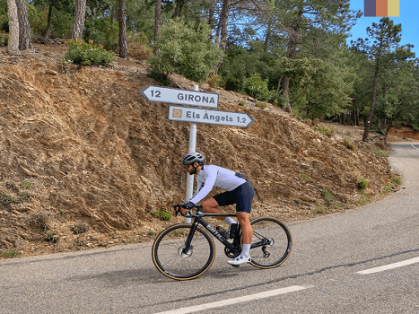 a road cyclist on the descent from els angels climb in girona, spain