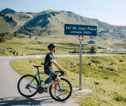 A cyclist at the top of the Col de Joux Plane in the Alps